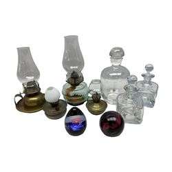 Two Caithness paperweights, together with four hand held oil lamps and three decanters  