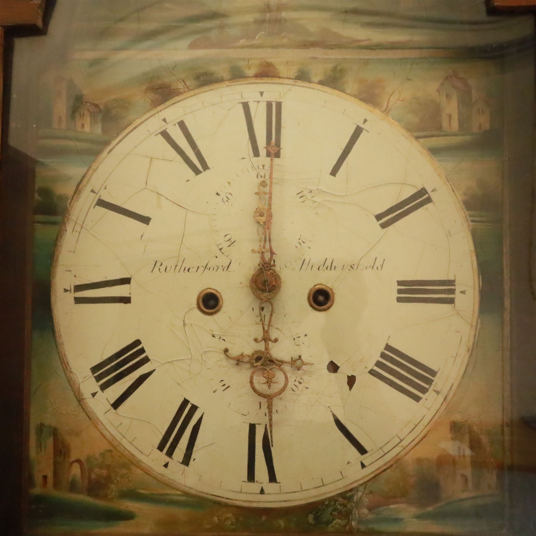 George Rutherford of Huddersfield- 8-day mahogany longcase clock c1880, with a swan neck pediment and turned patera, hood with shaped back splats and a break arch hood door flanked by ring turned pilasters, trunk with conforming recessed pilasters and a short wavy-topped trunk door, on a broad plinth raised on bracket feet, fully painted dial with matching pastoral depictions to the spandrels and break arch, with makers name, Roman numerals, subsidiary seconds and date dials and matching stamped brass hands, dial pinned via a falseplate to a rack striking movement striking the hours on a bell (bell missing). With pendulum, no weights.