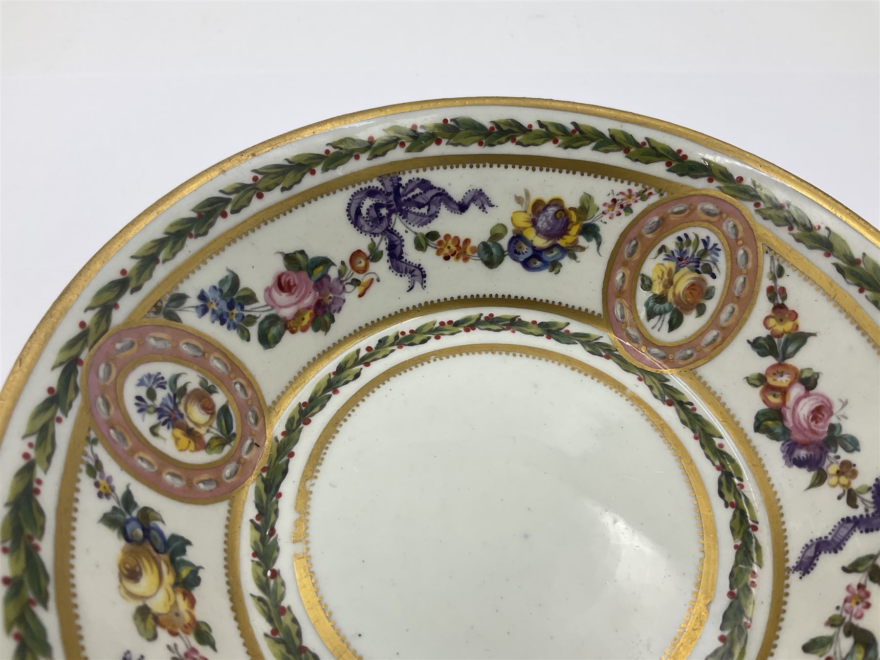 Sèvres soft paste porcelain coffee can and saucer with date code for 1780, painted with pink oval panels bordering bouquets of flowers, united by swags of flowers tied with purple ribbons, within laurel leaf borders, interlaced LL monogram enclosing date letters CC above painters marks for Nicquet, coffee can H7.5cm, saucer D15cm
