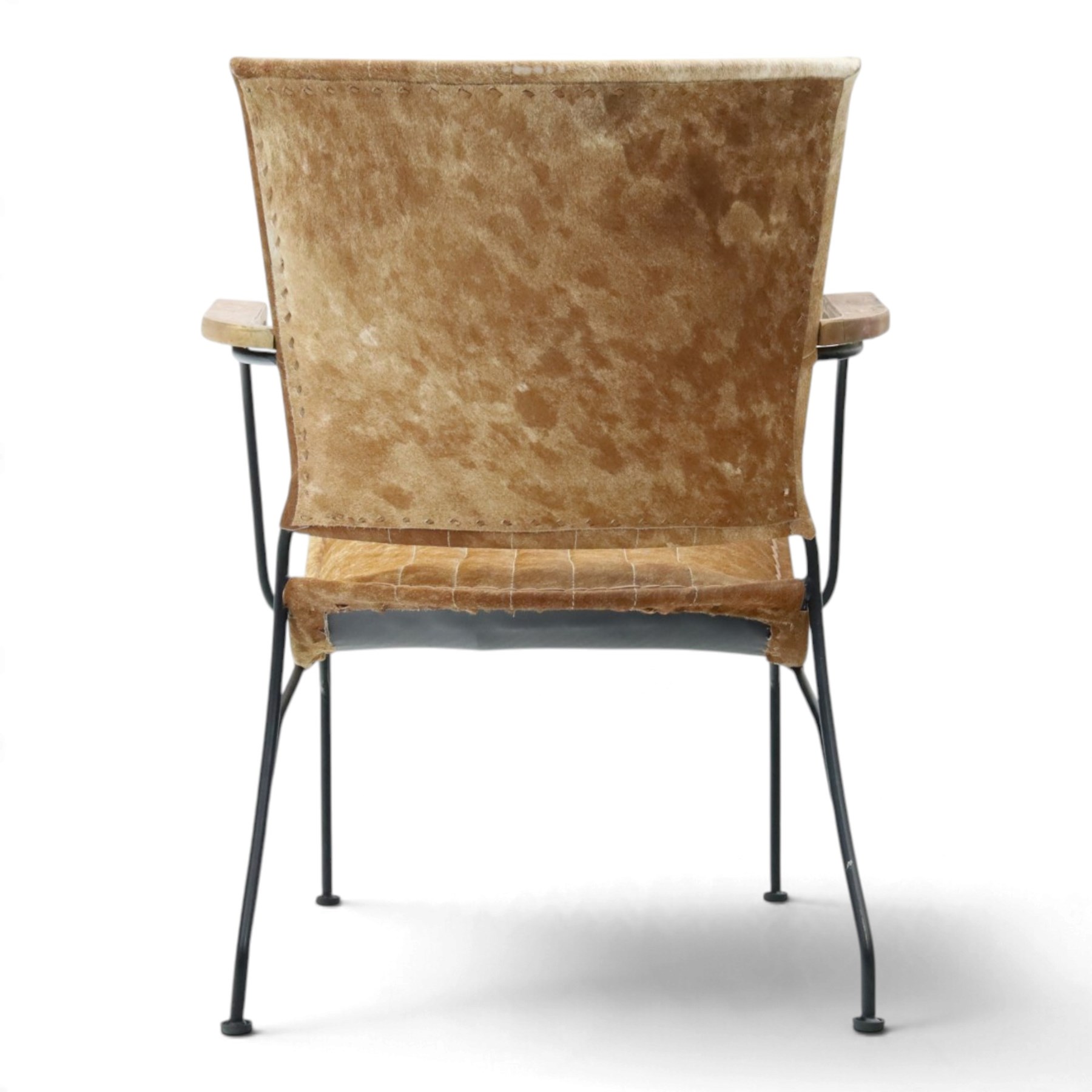 Mid century style cocktail cowhide chair, upholstered in tan cowhide, rectangular back and curved seat with stitched panels and laced borders, shaped wooden armrests on curved black metal supports 