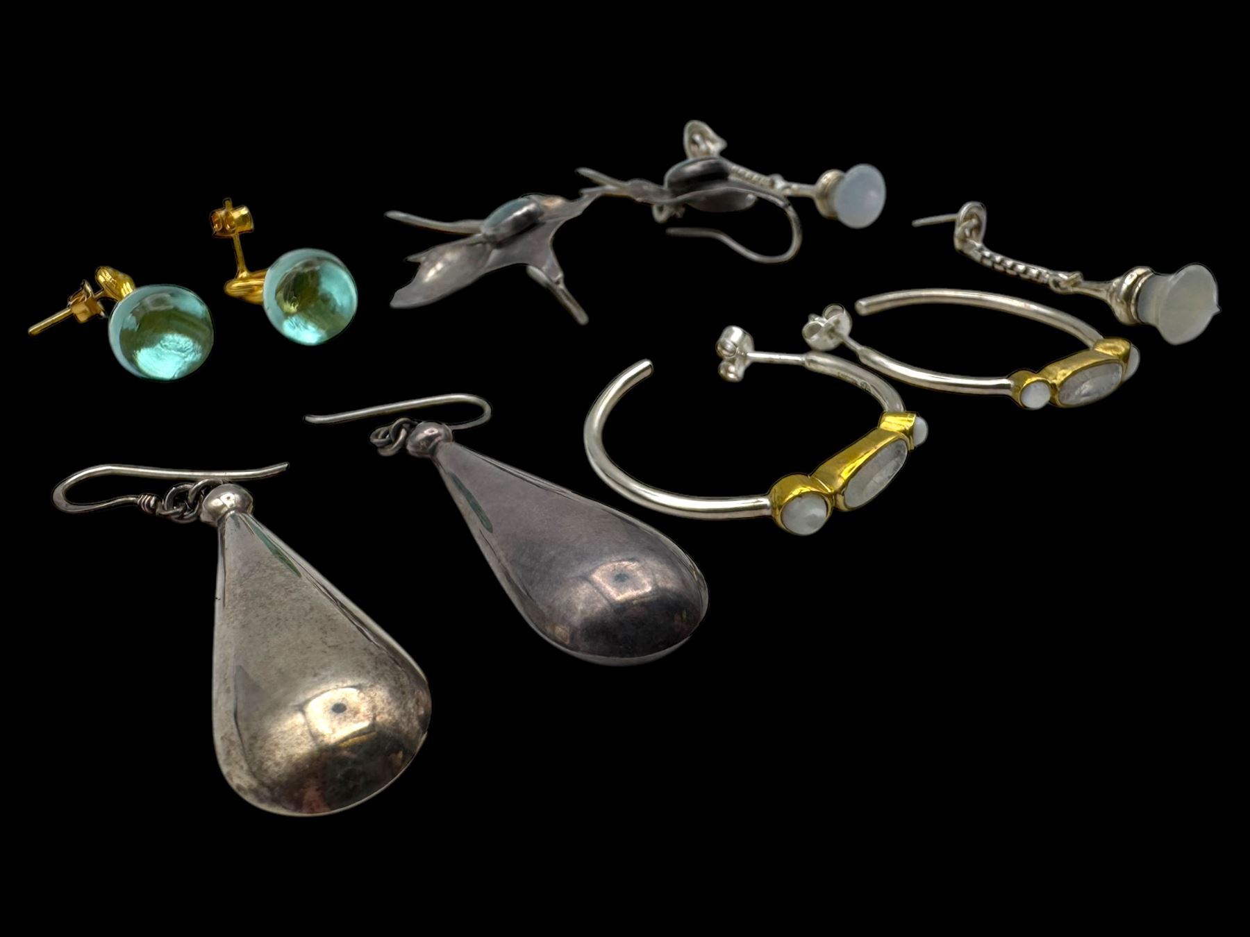 Six pairs of silver earrings, including opal pendant earrings and a pair of moonstone hoop earrings