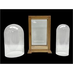 Tabletop glass display cabinet, with hinged door, together with two glass domes