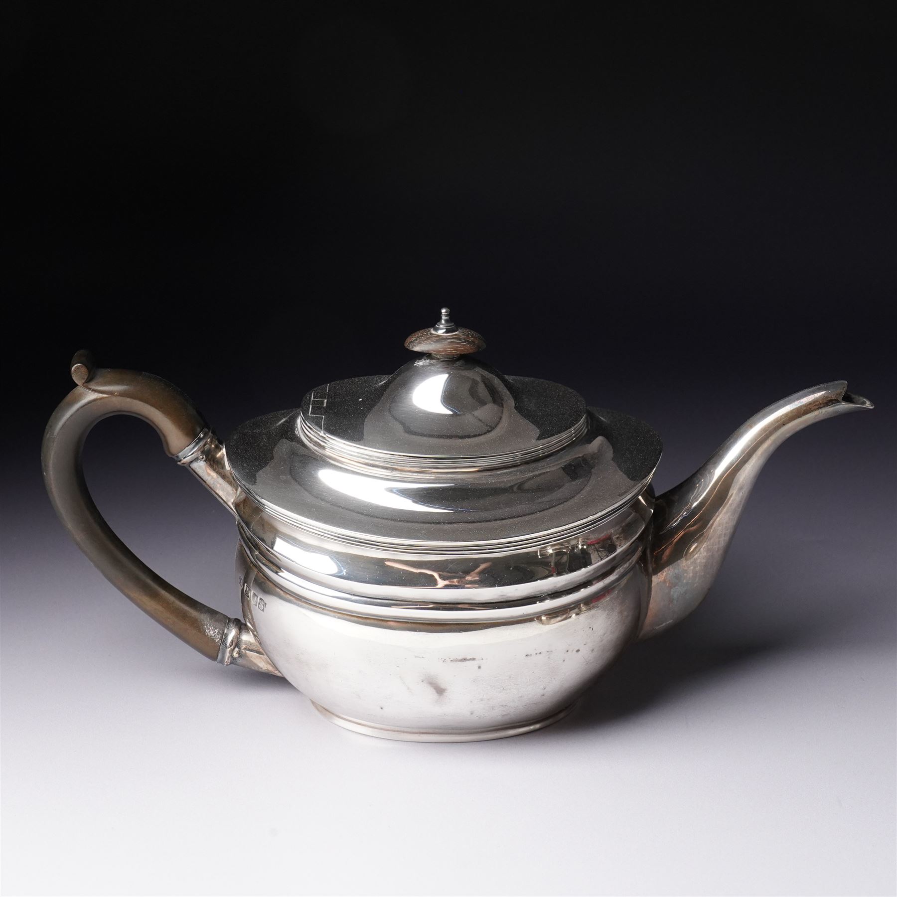 Silver three piece tea set of oval form, the teapot with ebonised handle and lift London 1913 Maker John Hunt and a pair of Victorian silver sugar tongs