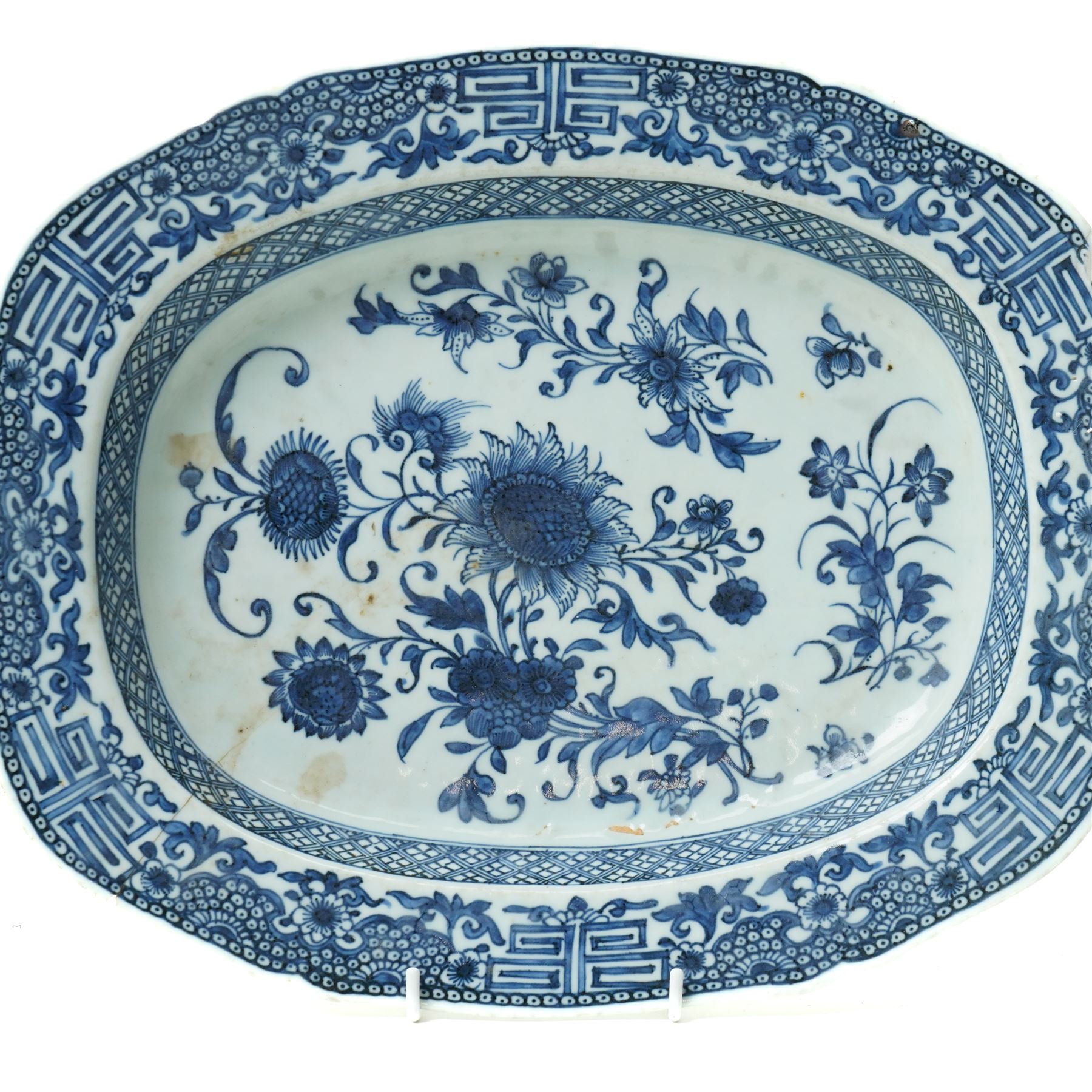 18th century Chinese oval dish shallow dish decorated with flowers in blue and white within a scroll and key pattern border W37cm and a Chinese blue and white charger D34cm (2)