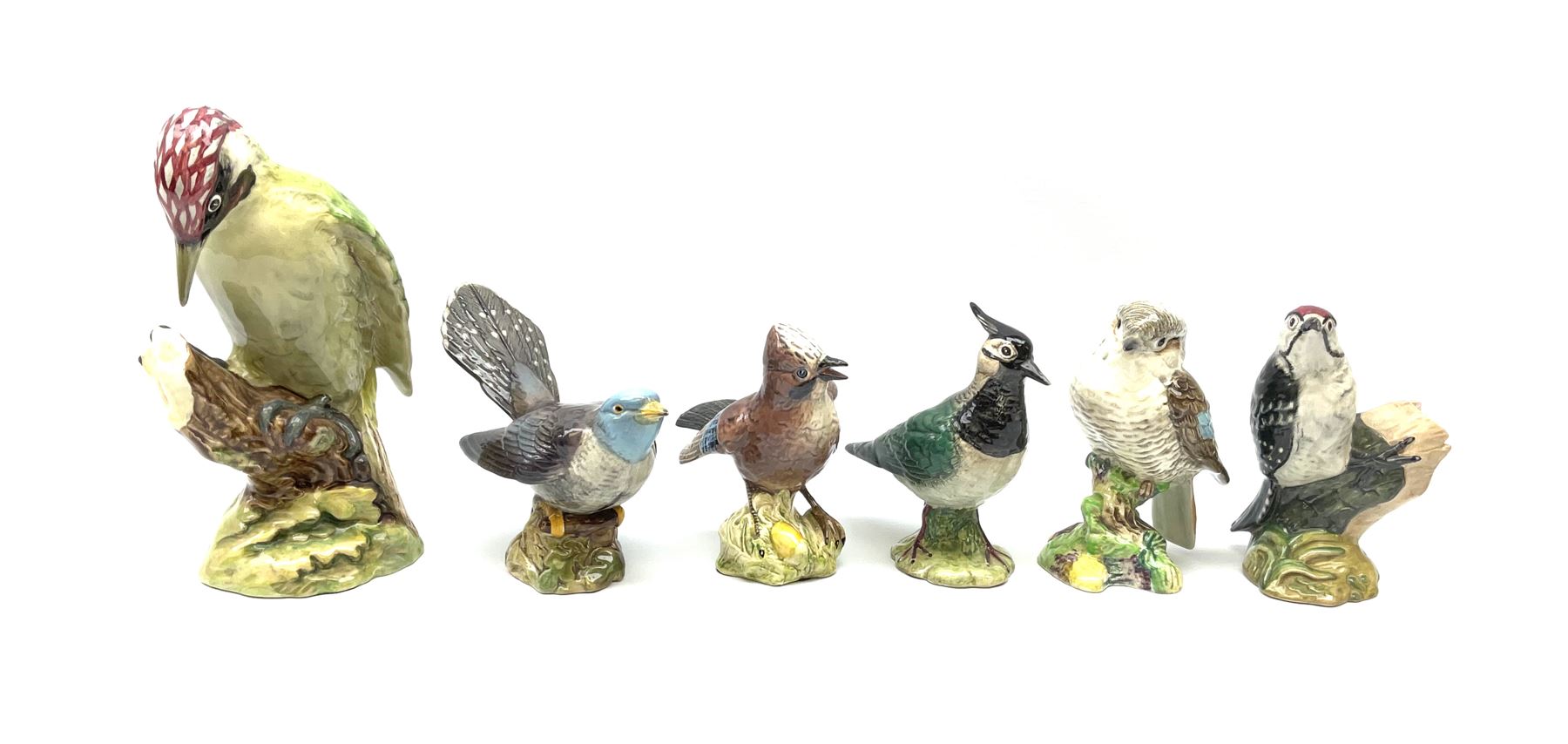 Collection of Beswick birds, comprising woodpecker model no 1218, jay model no 2417, cuckoo model no 2315, lapwing model no 2416, lesser spotted woodpecker model no 2420, and kookaburra 1159. 