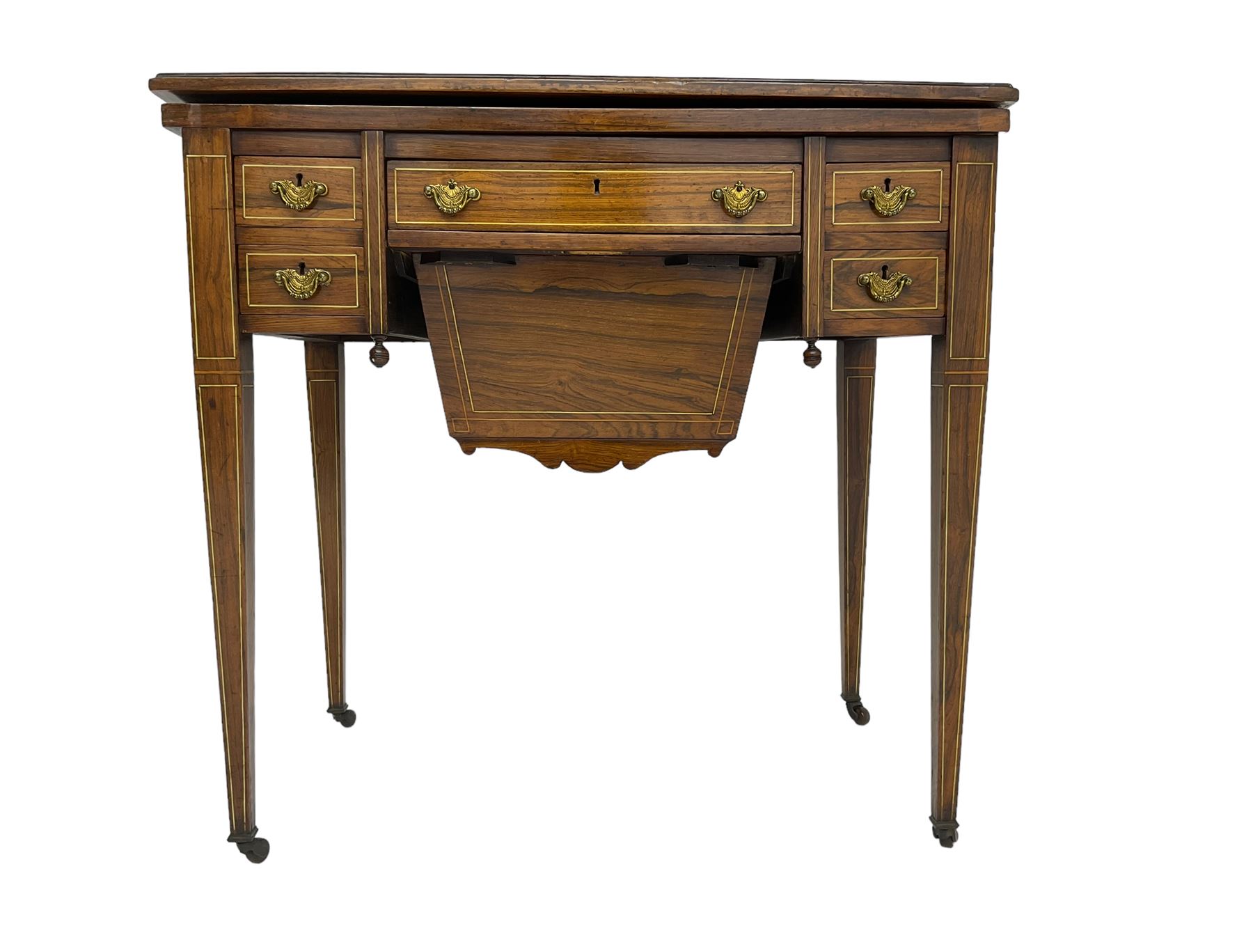 Edwardian inlaid mahogany games or work table, rectangular fold-over top inlaid with stylised dragon ivorine decoration and stringing, fitted with one long flanked by four small drawers over sewing compartment drawer, raised on square tapering supports with castors