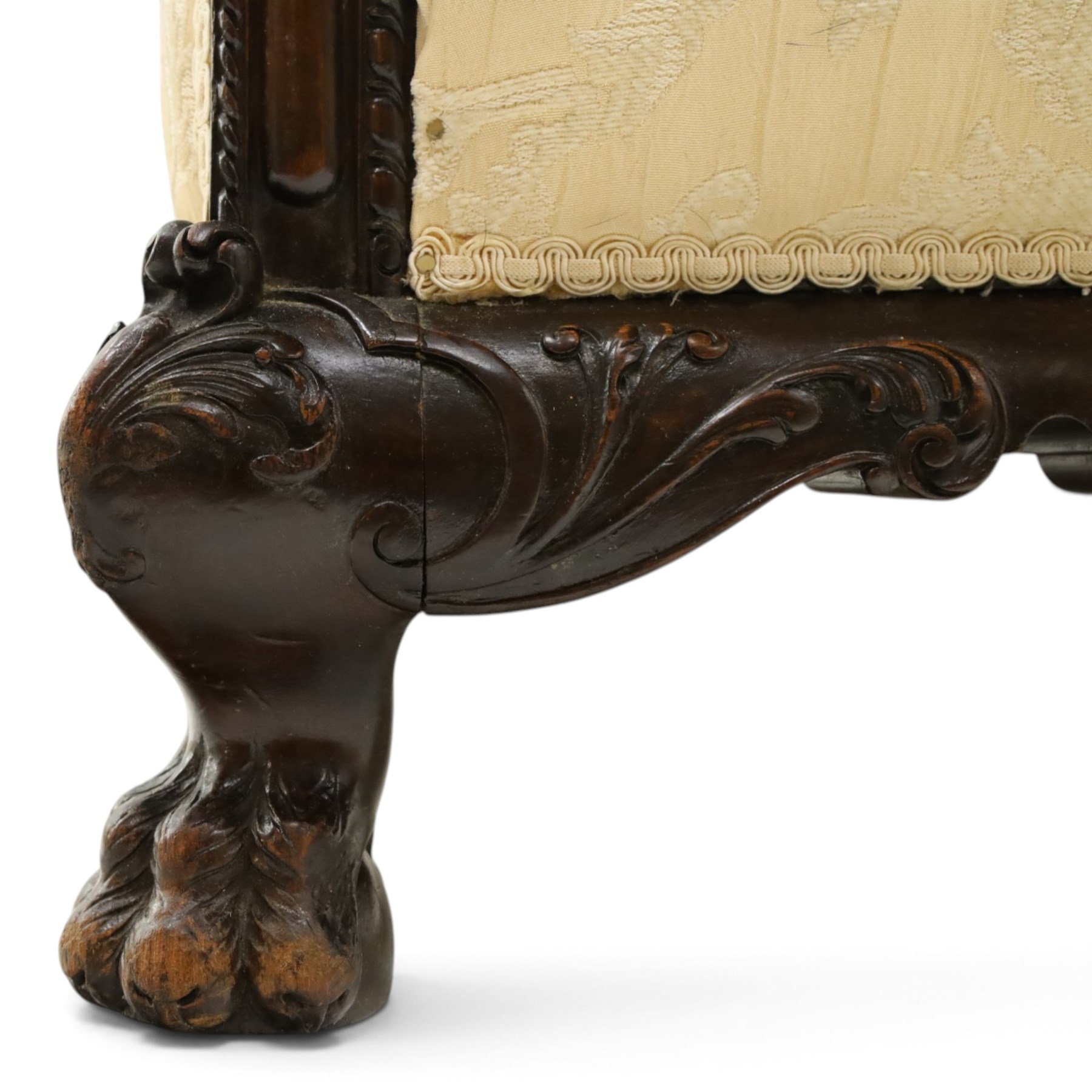 Quality Edwardian carved mahogany lounge suite comprising three-seater settee and pair of armchairs, the sofa with arched back over rolled arms and deep sprung seat, the arm terminals carved with acanthus rosette over gadroon and rope-twist moulding, the shaped apron carved and moulded with scrolling foliate acanthus motifs, terminating to four large front hairy paw and ball feet, upholstered in pale yellow foliate fabric with matching seat and scatter cushions (W200cm D105cm H73cm); the matching deep armchairs (W78cm D95cm H75cm)