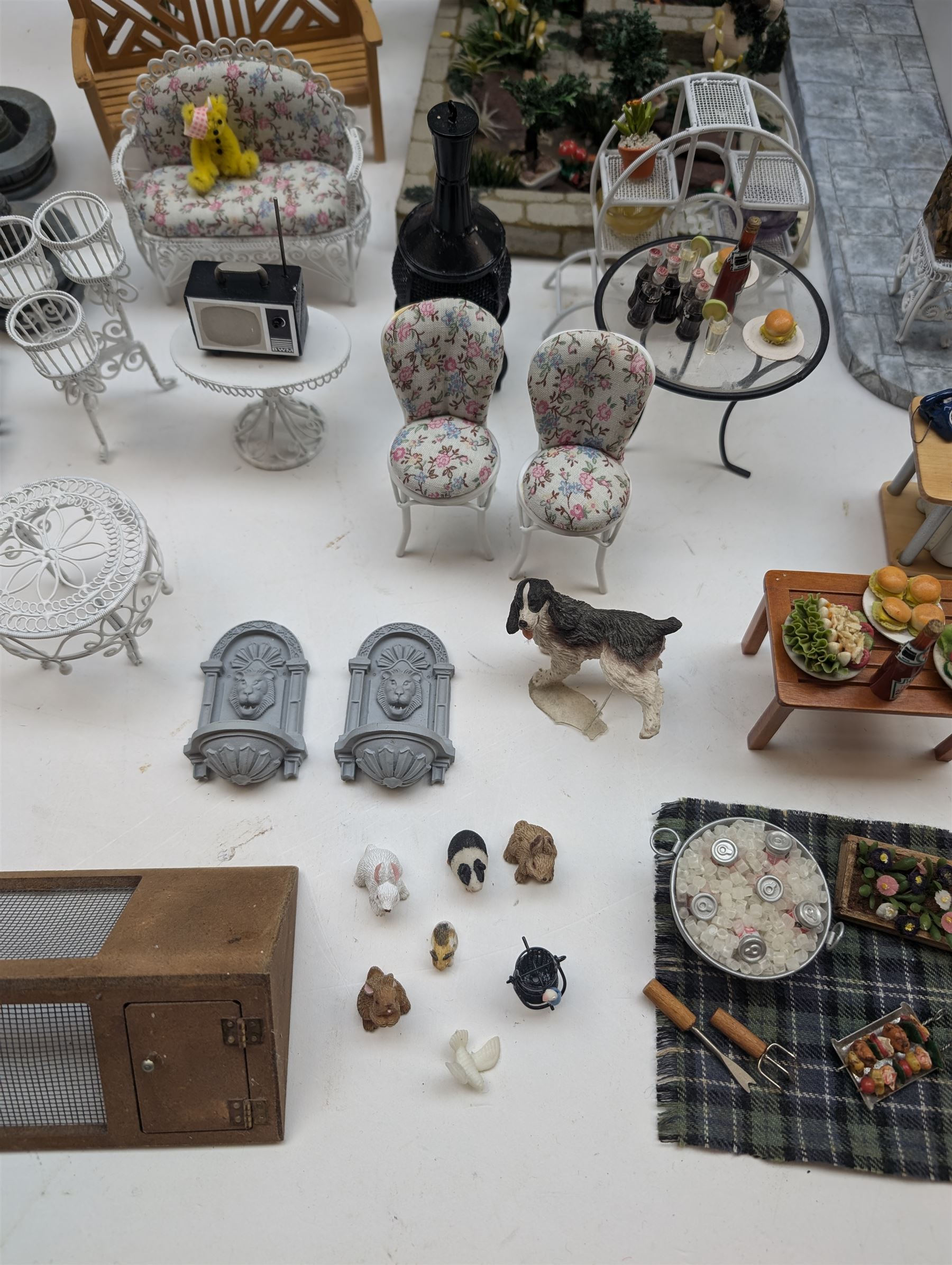 1:12 scale dolls house conservatory and garden accessories, including white wooden glazed conservatory on a stone effect base, black and white metal garden seating, barbecue, plant shelves, parasol, barbeque accessories, large planters, rabbit hutch, animals, chimenea, etc