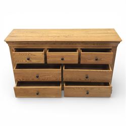 Contemporary oak veneered sideboard, moulded rectangular top above a six drawer arrangement, three over three, each drawer with turned ebonised style knob handle, panelled ends, raised on a shaped plinth base with bracket feet
