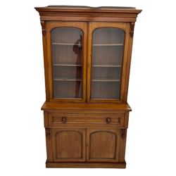 Victorian mahogany bookcase on secretaire, the stepped moulded cornice over two glazed doors enclosing three shelves, fall front secretaire drawer with fitted interior, double panelled cupboard below, plinth base