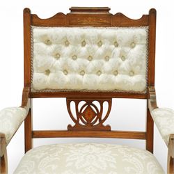 Edwardian mahogany open armchair, the upholstered rectangular back buttoned in ivory patterned fabric within a shaped top rail with inlaid foliate detail, open splat carved with a pierced anthemion motif centred by an inlaid roundel, swept open arms with upholstered pads, over a sprung upholstered seat, on turned front supports with brass castors