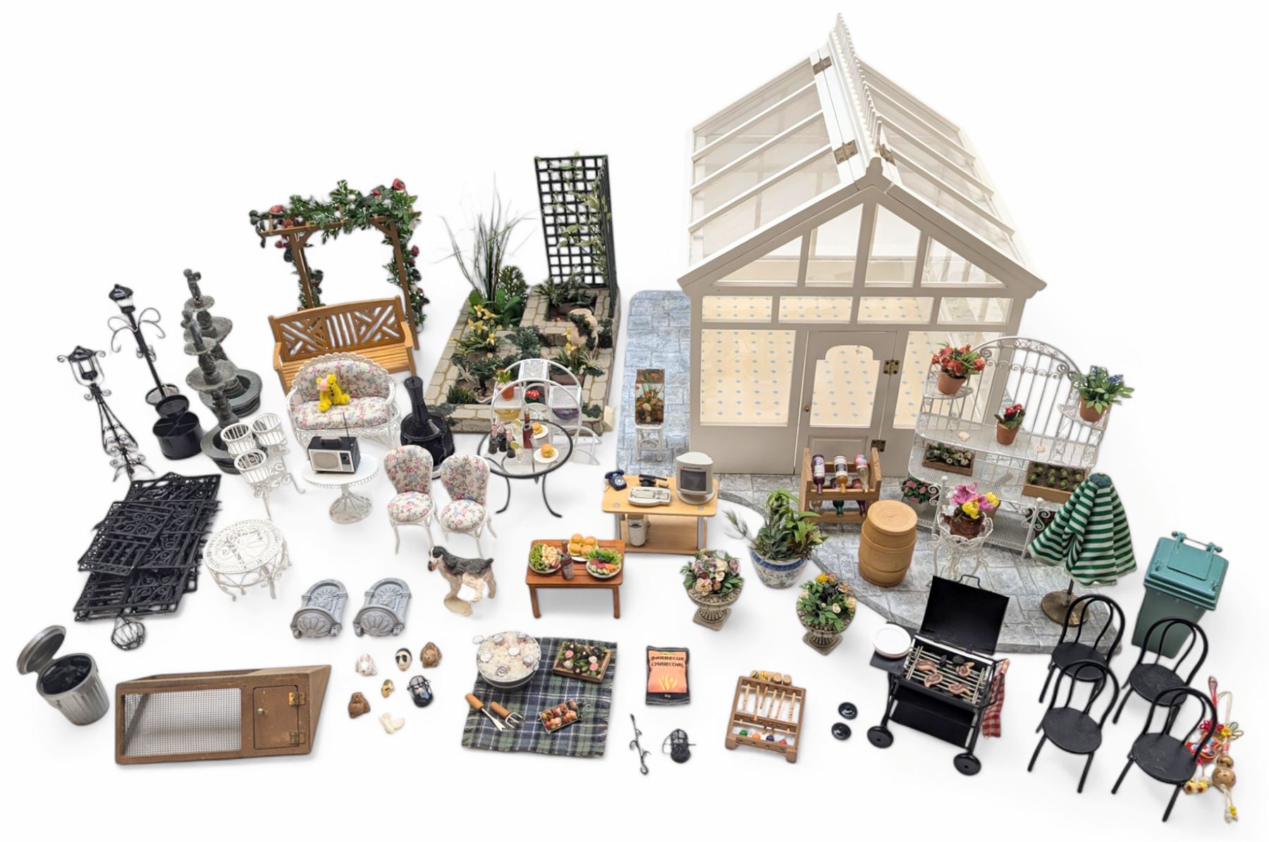 1:12 scale dolls house conservatory and garden accessories, including white wooden glazed conservatory on a stone effect base, black and white metal garden seating, barbecue, plant shelves, parasol, barbeque accessories, large planters, rabbit hutch, animals, chimenea, etc