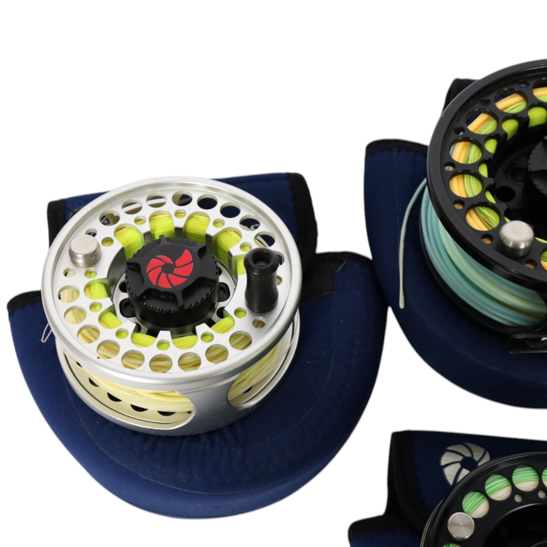 Four Nautilus USA fly reels, comprising T12, no. five and two no. ten models, all within Nautilus pouches
