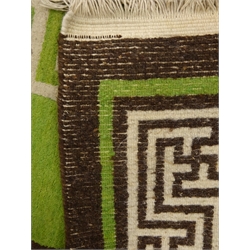  Large oriental brown and green ground rug, geometric pattern field, repeating border, made to order in the Tibetan Refugee Centre, Darjeeling in 1976, 254cm x 370cm  
