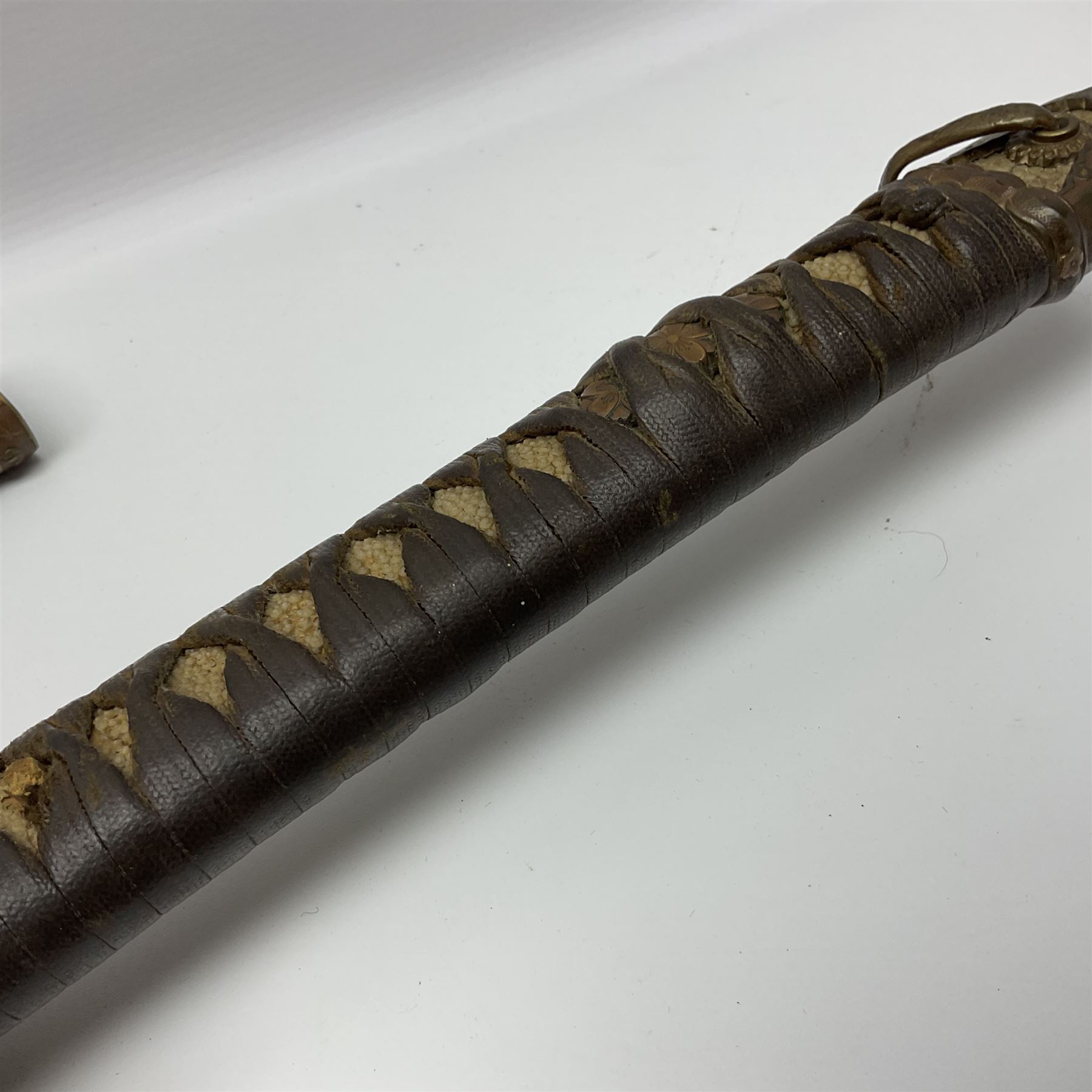WW2 Japanese Army officer's shin gunto/katana sword with 68.5cm steel single edged blade, foliate cast brass tsuba, bound fish-skin grip with brass mounts, inscribed marks to both sides of tang; in lacquered wooden scabbard with brass mounts and locking button L97cm overall