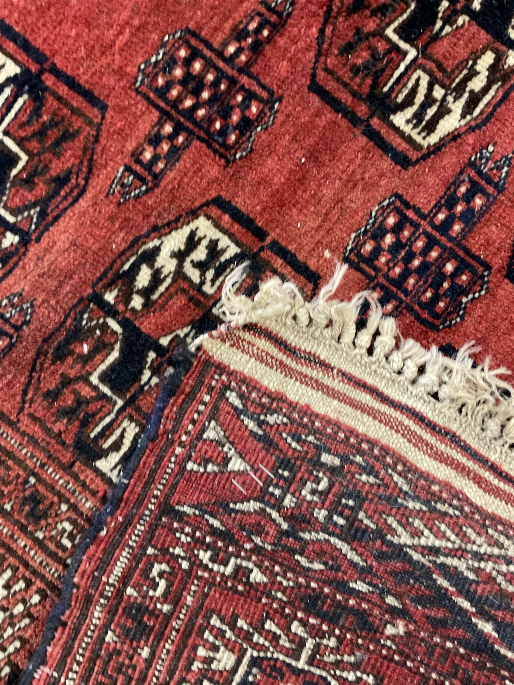 Bokhara red ground rug, decorated with two rows of Gul motifs, the border with geometric guard bands decorated with stylised plant motifs