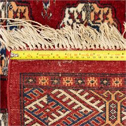 Two hand-knotted rugs, comprising Persian floral rug, dark blue ground decorated with scrolling foliage and flowerheads within a red floral border (H 208cm, W 134cm); Bokhara type rug, red ground with repeating gul motifs and geometric guard borders (H 174cm, W 94cm)