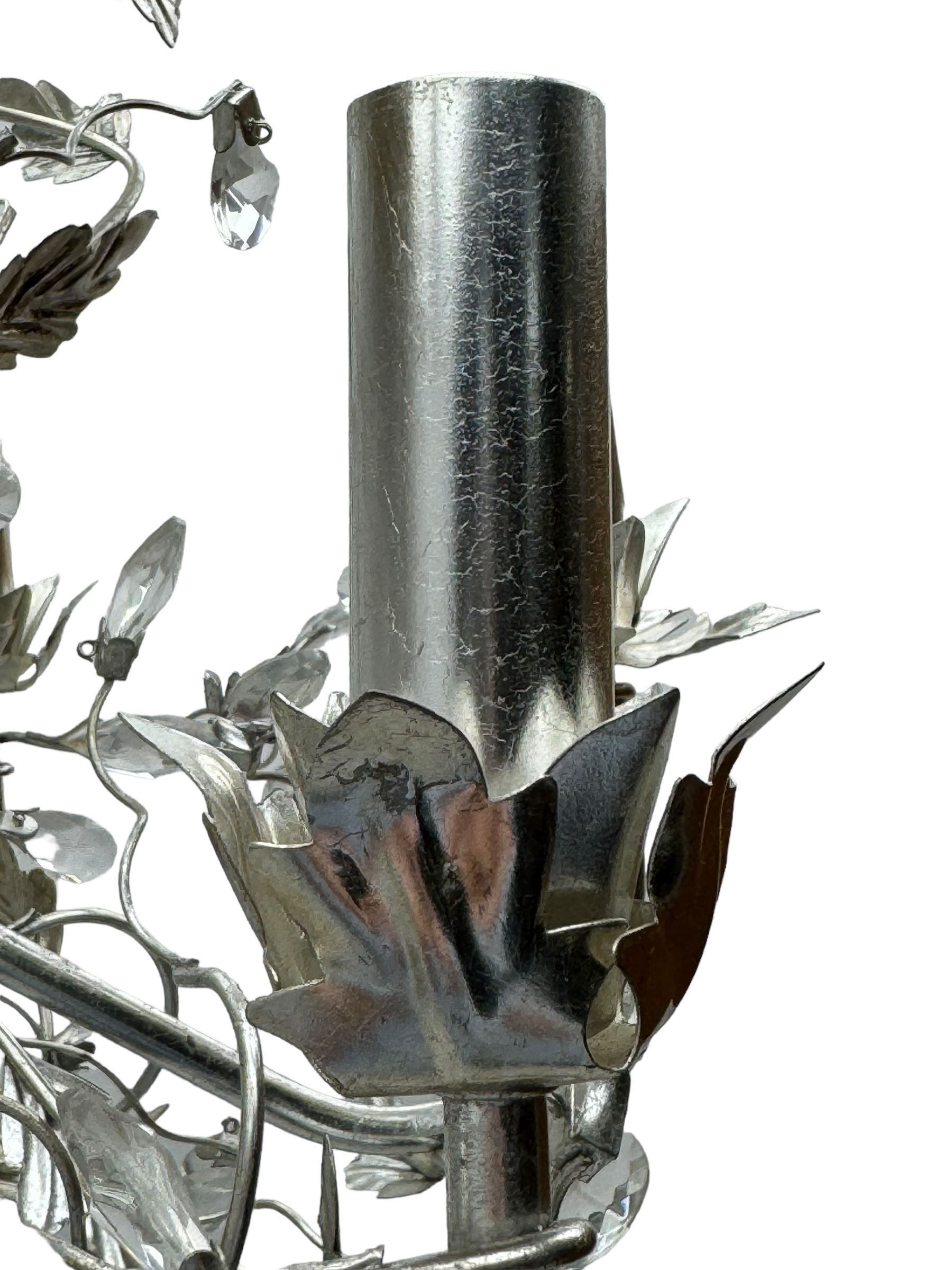 India Jane - silver finish metal chandelier, modelled with scrolling vines and leaves, embellished with faceted glass drops, fitted with six candle sconces, and wired for electricity
