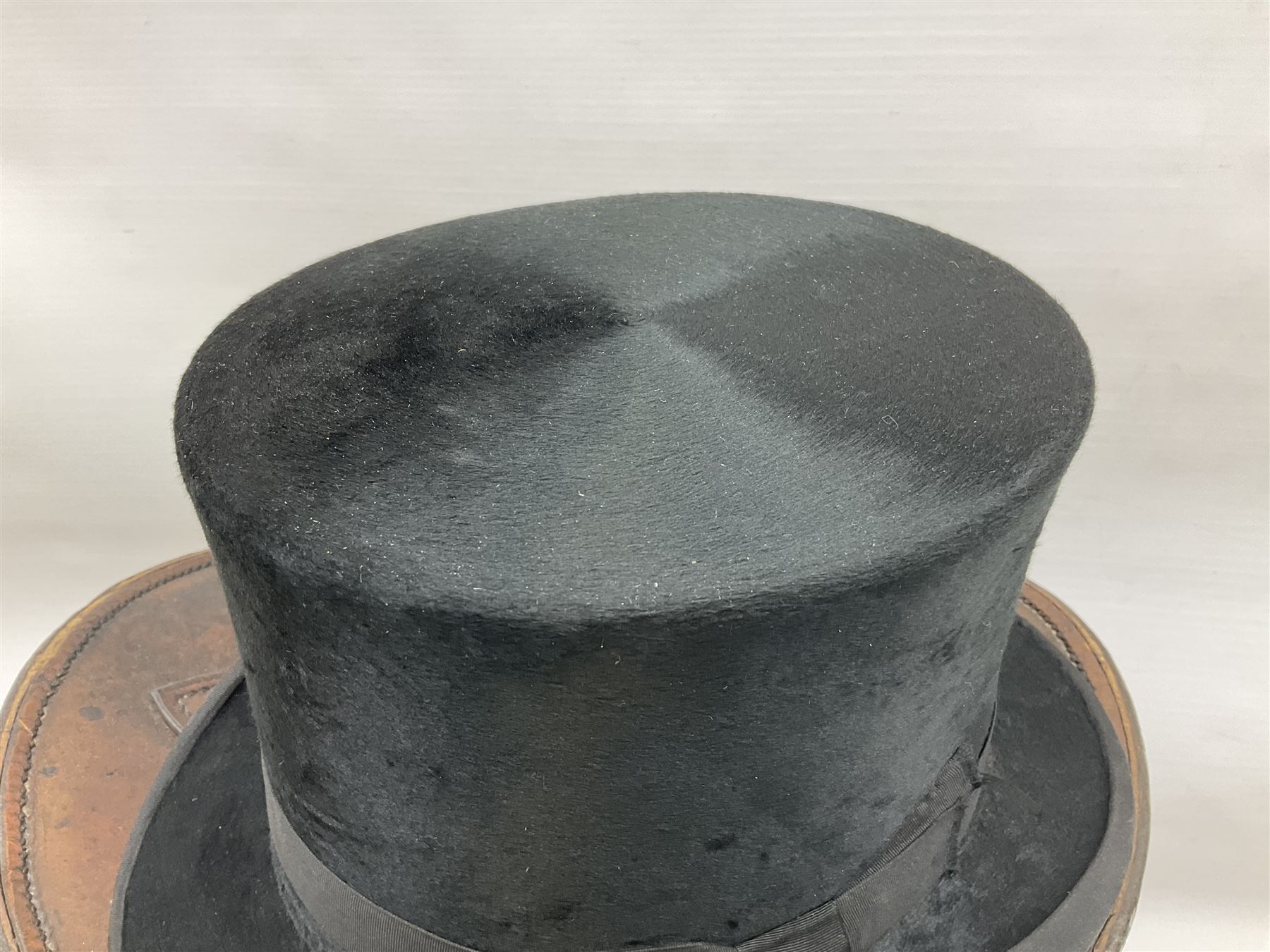 Early 20th century black silk top hat by Woodrow of Manchester and London, with manufacturer's stamp to the silk lined interior, housed in fitted tan leather hat box with removable internal compartments with straps, brass escutcheon and engraved plaque, hat internal measurements approx 20cm x 15cm