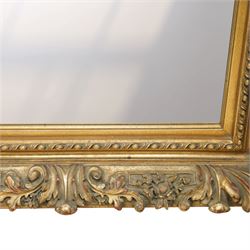 Rococo revival style giltwood and gesso wall mirror, the rectangular frame with layered mouldings, the main frieze carved with scrolling acanthus leaves and stylised floral detail, the inner edge enriched with bead-and-reel moulding, enclosing a rectangular mirror plate