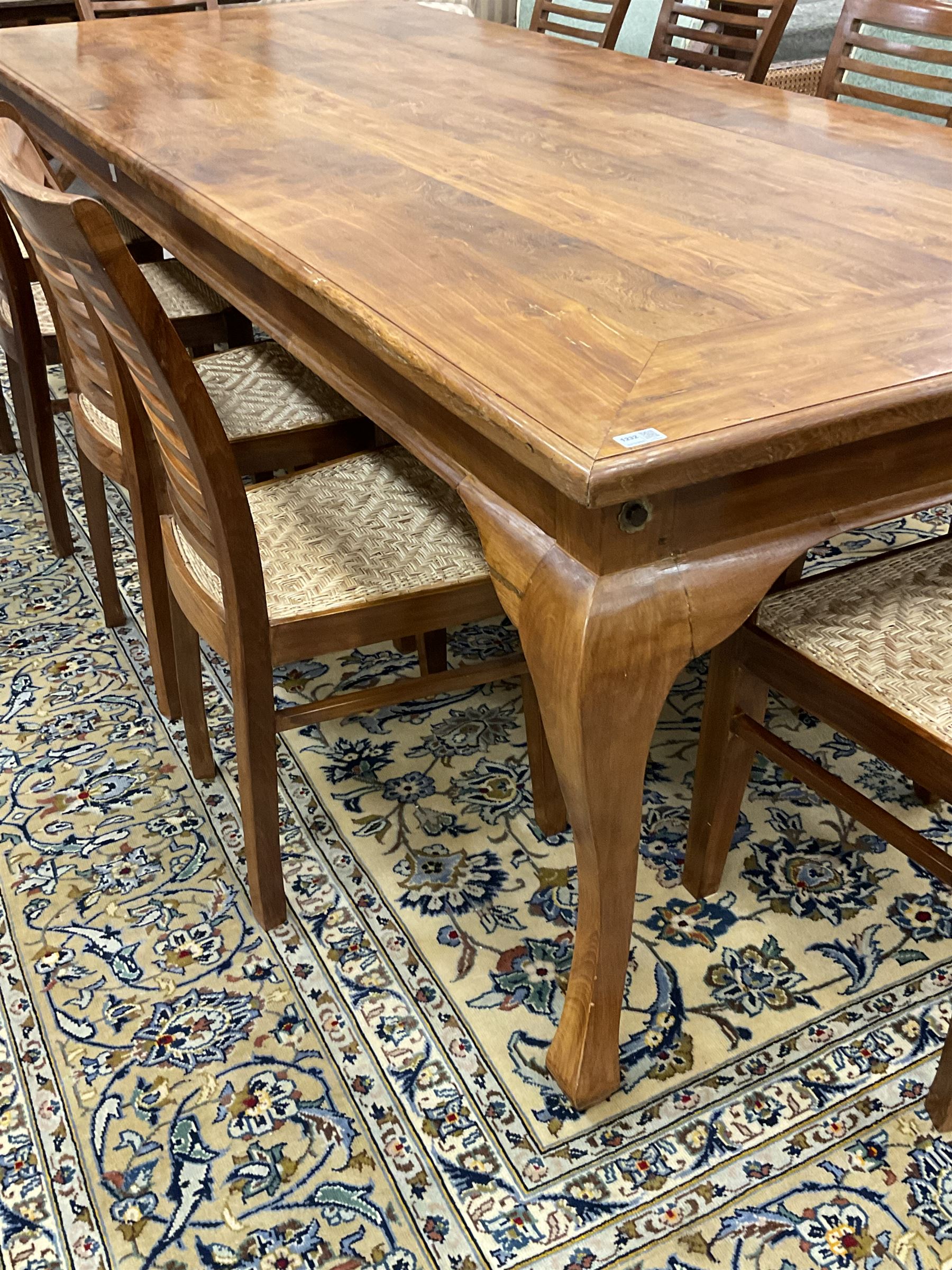 Large teak dining table, moulded rectangular top, on cabriole supports, together with a set of ten ladder back dining chairs with cane work seats