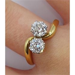 Early 20th century 18ct gold and platinum two stone old cut diamond crossover ring, stamped, total diamond weight approx 1.30 carat