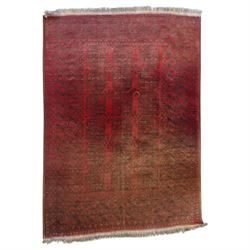 Afghan crimson ground Bokhara rug, the field with three rows of repeating Gul motifs, with...