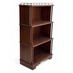 Mid-20th century mahogany open bookshelf, the rectangular top with a brass balustrade gallery, over three shelves each supported by turned column uprights, on shaped apron base
