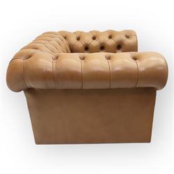 Contemporary set of two tan leather armchairs, comprising a deep-buttoned chesterfield and a matching wingback chair, both with rolled arms, studded borders