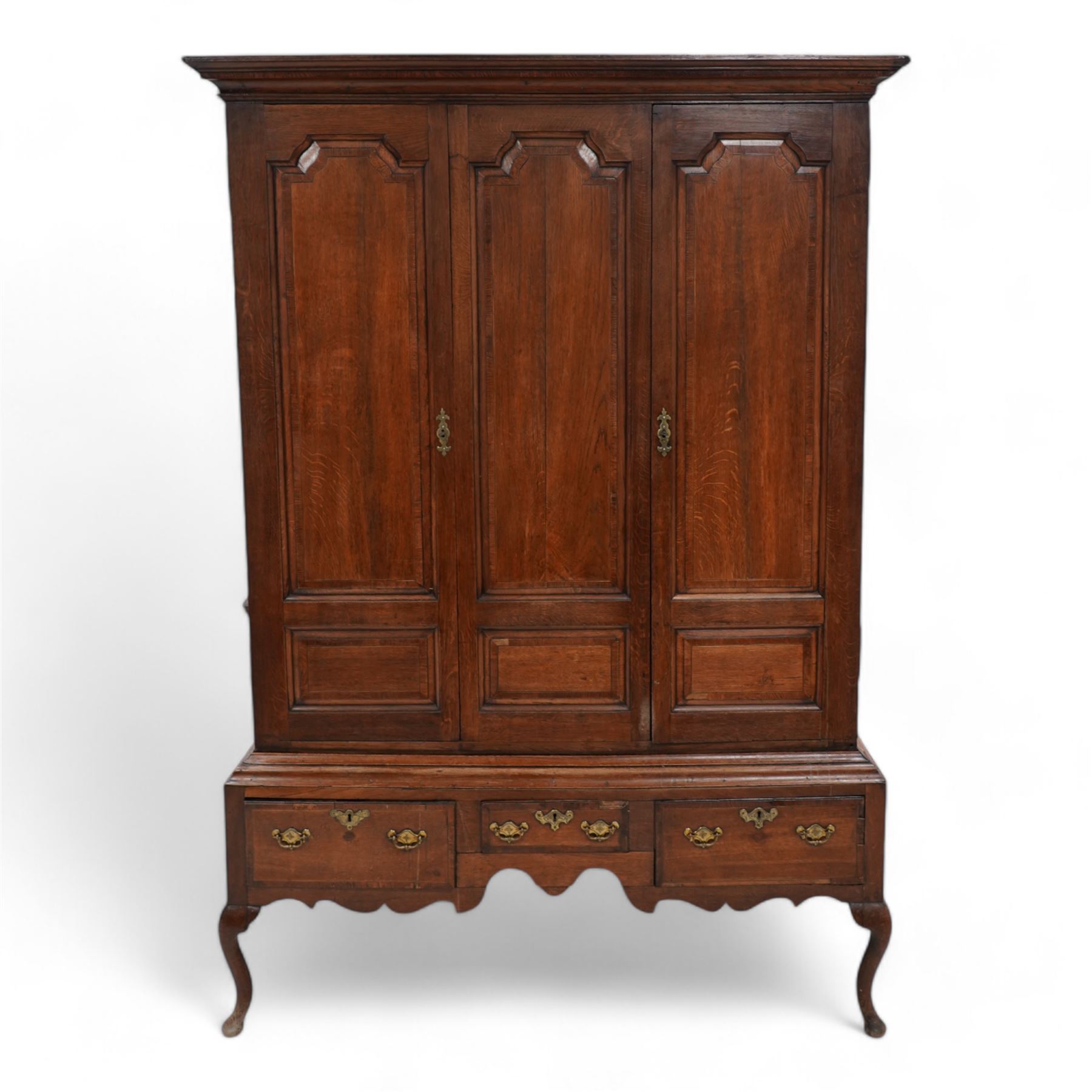 Georgian oak livery cupboard, projecting cornice over panelled front with mahogany bandings, enclosed by two doors, the base fitted with three drawers over shaped apron and cabriole supports 