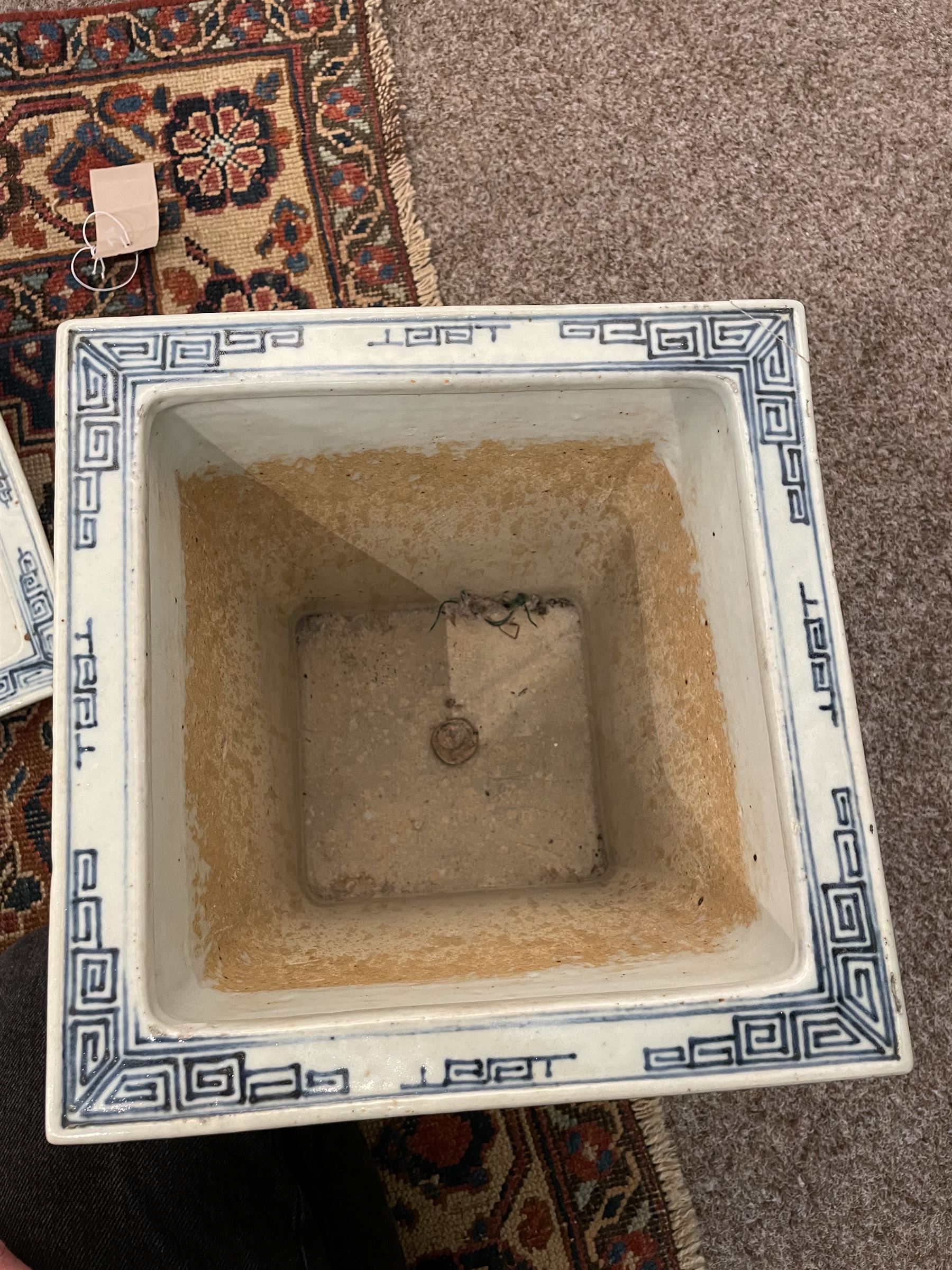 19th century Chinese blue and white planter and stand, each of square slightly tapering and flared form, the planter decorated with figures and precious objects between stylised foliate borders, the stand decorated with landscapes beneath a lipped rim with cell band, planter H28cm D25.5cm, stand H7cm D26cm
