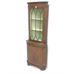 20th century mahogany corner display cabinet,  projecting cornice, dentil frieze, single glazed door enclosing two shelves, above single cupboard door , shaped bracket supports 