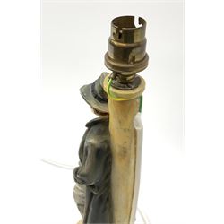 A moulded resin table lamp, modelled as a man in 1940s dress leaning against a lamp post, including fitting H32cm.