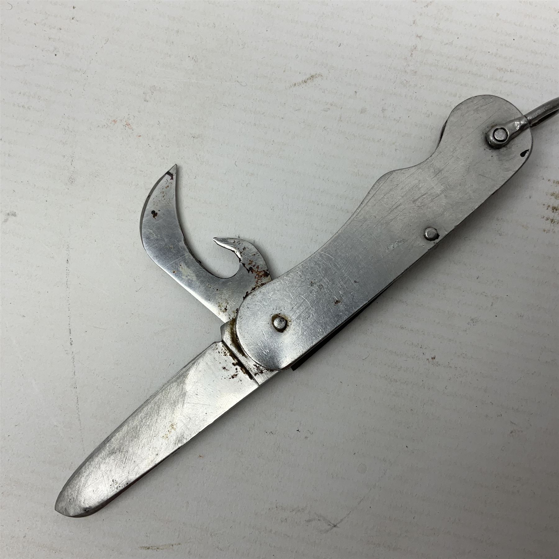 Fairburn Sykes style third pattern commando fighting knife, the 16cm double edged blade with central medial ridge, steel cross-piece marked with broad arrow and 'I', ribbed alloy grip L28cm overall (no scabbard); and Warriss Sheffield military pocket knife with two folding blades, marked with 'broad arrow 1953 and Oil The Joints' (2)