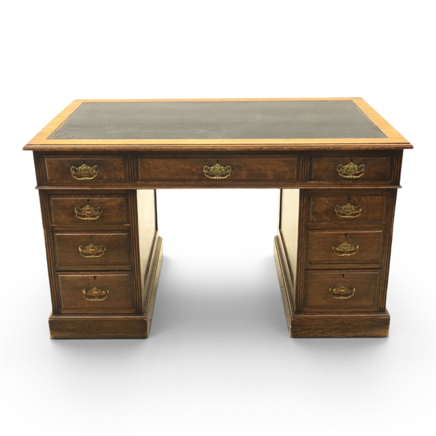Oak twin pedestal desk with leather top, moulded rectangular top with inset black leather writing surface, nine fielded panelled drawers with brass handles, raised on a plinth base with castors