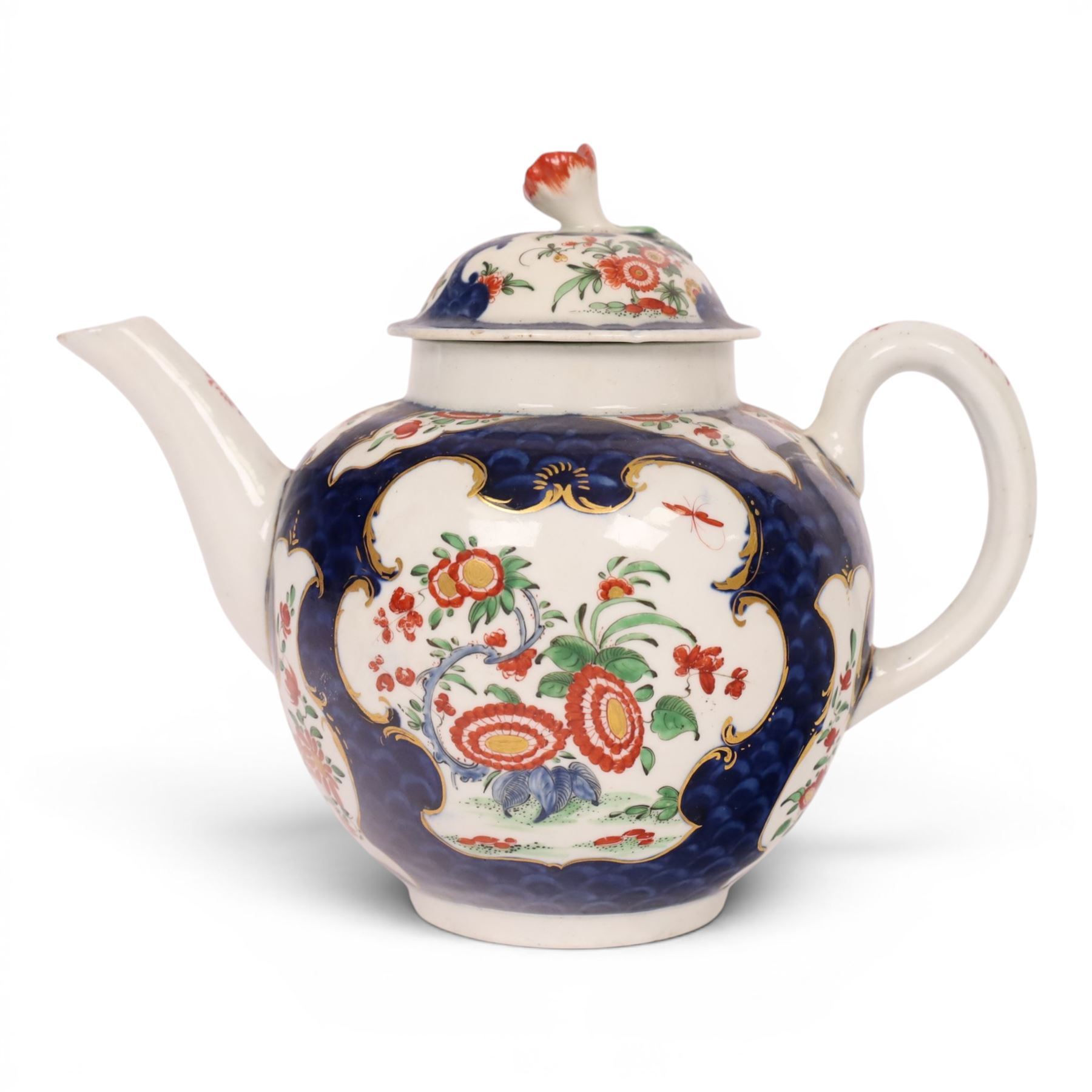 18th century Worcester teapot, circa 1763-70, of globular form, painted with shaped panels of chrysanthemums and banded hedges on a blue scale ground, cover with flower finial, mark beneath, H15cm