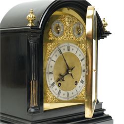 Winterhalder & Hoffmeier-8-day early 20th century mantel clock with an ebonised finish, break arch pediment and two matching brass finials, conforming glazed door with a cast brass bezel flanked by reeded quarter pilasters, on a moulded plinth with scroll feet, brass dial with cast spandrels and strike/silent and pendulum regulation dials to the arch, matted dial centre with a silvered chapter, Roman numerals  and gothic steel hands, dial pinned to a quarter striking movement sounding the quarters on two gongs and hours on one. With Pendulum.
