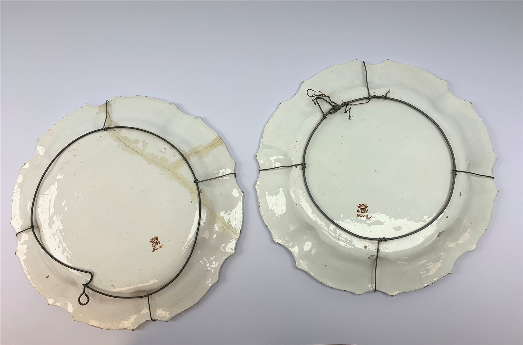 A pair of Italian faience pottery plates, by Giovanni Battista Viero, each of circular form with piecrust rim, with painted floral decoration, each with painted mark beneath, (a/f), D37.5cm