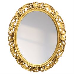 Late 19th century giltwood oval wall mirror, the bevelled plate within a gadroon moulded inner slip, surrounded by pierced scrolling foliate and acanthus carved frame, richly gilded with worn patina indicative of age and use