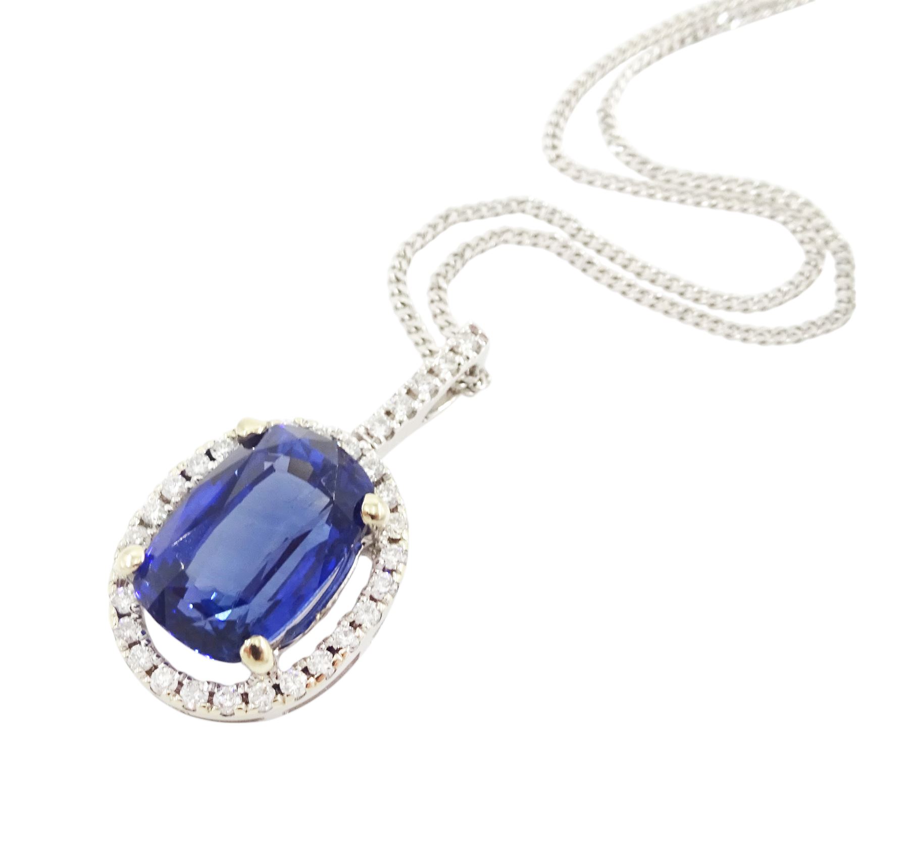 18ct white gold sapphire and diamond halo pendant necklace, single cushion cut sapphire of approx 4.65 carat, with round brilliant cut diamond surround and bail, on fine flattened curb link chain necklace, both hallmarked, total diamond weight approx 0.35 carat