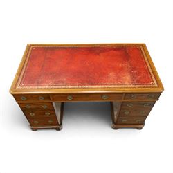 Late Victorian mahogany desk with red leather top, rectangular top with inset toold red leather writing surface, central long frieze drawer flanked by two short drawers, above pedestal with three graduating drawers with ring pull handles, on moulded plinth bases raised on castors