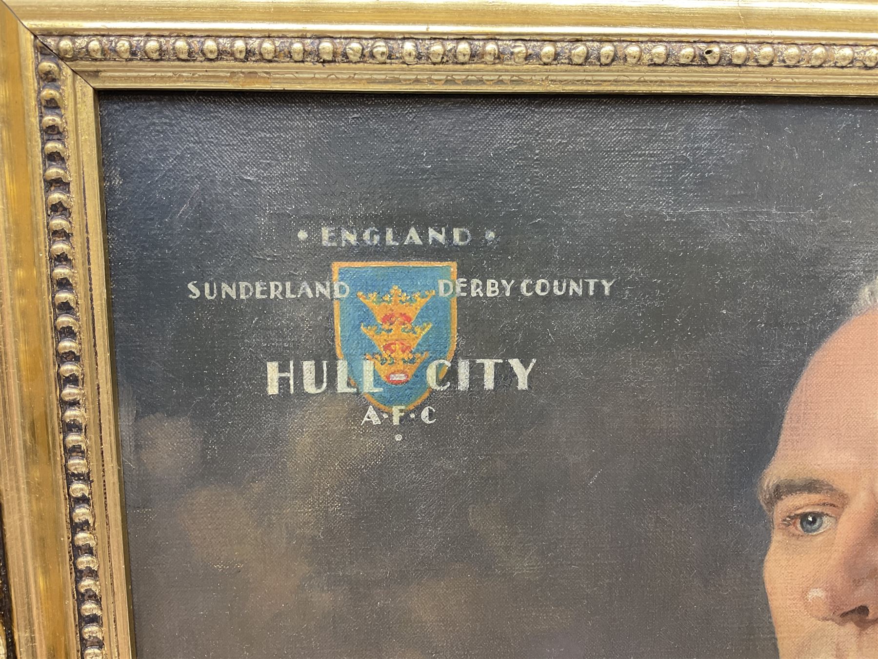 Roland F. Spencer Ford (1902 - 1990), oil painting on canvas, half length portrait of Raich Carter, standing dressed in Hull City kit, the Hull town crest in the background surrounded by the names Hull City A.F.C., Sunderland, Derby County and England, bears label verso from the studio of the artist in Newstead Street, Hull with original price of £75, signed, 59.5 x 49.5cm, gilt frame with metal plaque inscribed ' Presented by the Management Committee/of the Hull City Supporters Clubs/as a mark of esteem and appreciation/for services rendered to/Hull City A.F.C./and to football in general/October 1952'. Provenance: By direct descent from the family of Raich Carter having been consigned by his daughter Jane Carter.