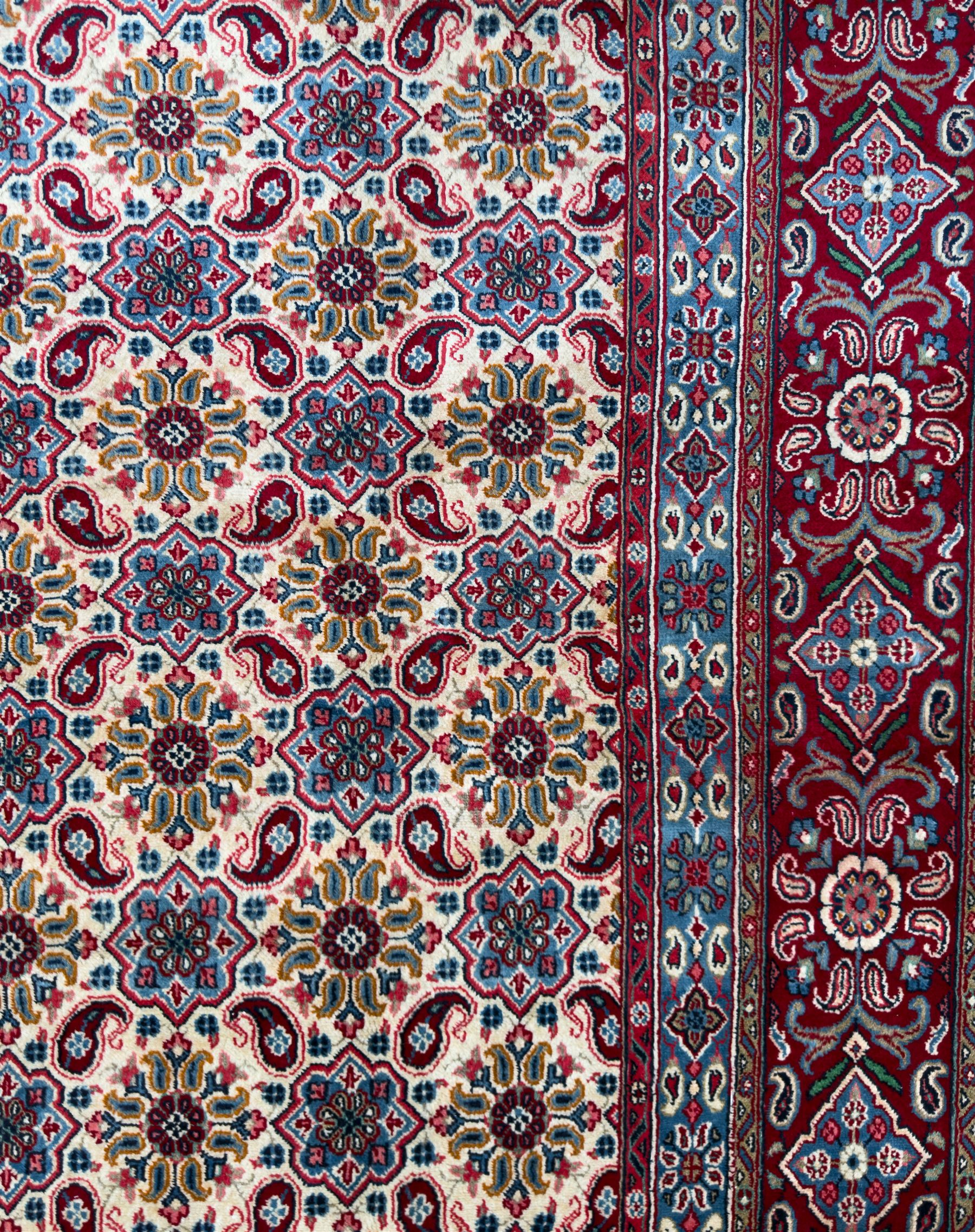 Northwestern Persian Hamadan carpet, hand-knotted, ivory field with an all-over Herati design of rosettes and serrated leaves within multiple borders, madder red with angular vine and rosette motifs, 375cm x 271cm 