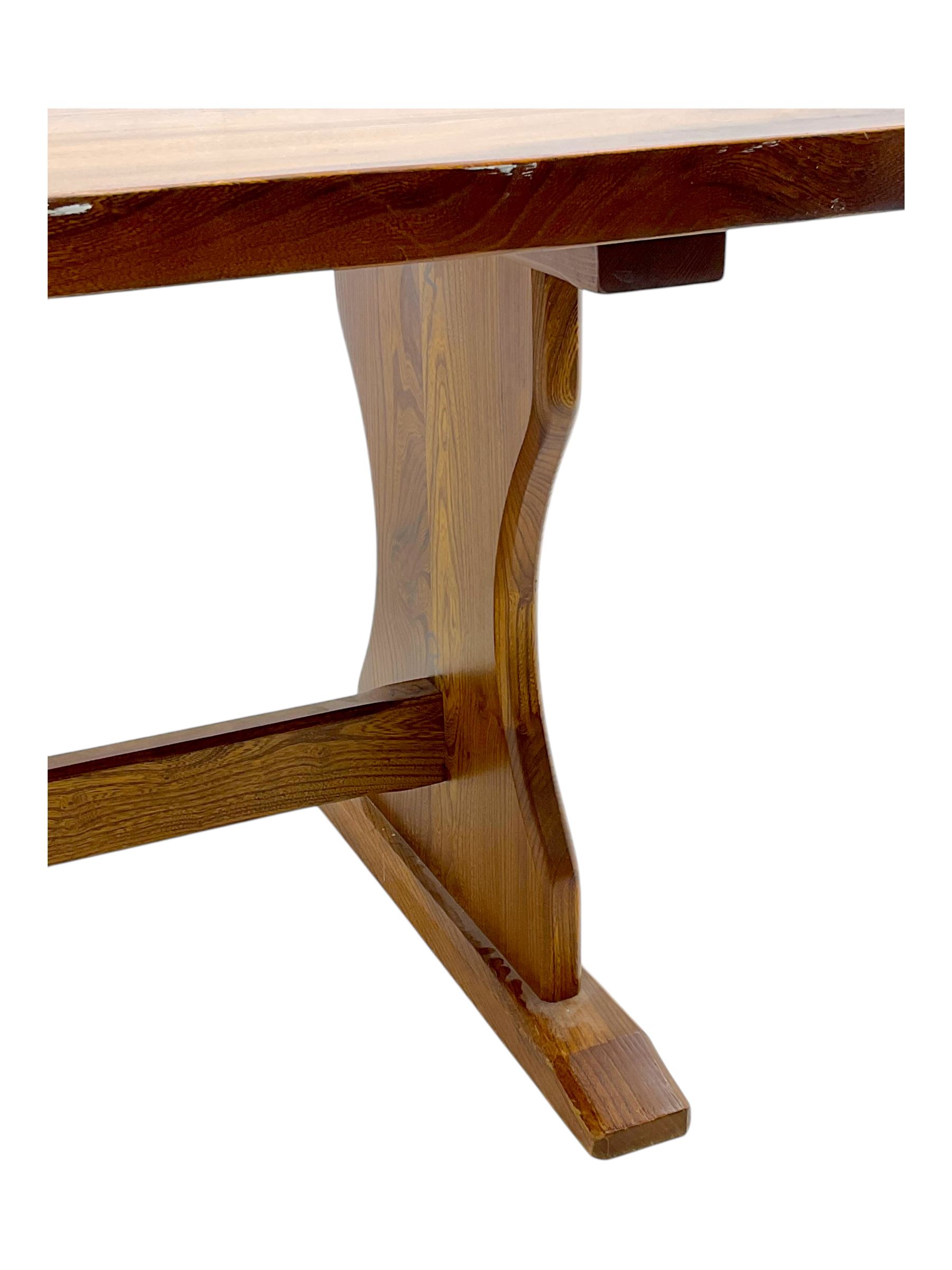 Late 20th century oak trestle table, rectangular top with naturalistic edge, supported by two curved pedestal bases united by central stretcher, on block feet