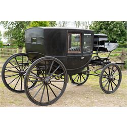 Town Coach by John Marstons Birmingham - Ex Film

A black painted five glass Town Coach by John Marston's Carriage Works Ltd, Birmingham, with enclosed glazed passenger compartment, curved front glass, external coachman's box seat and pole for driving with a pair of horses. The carriage has a timber coach body with buttoned black leather interior, blue upholstered seat cushions, plated exterior door handle, maker plates to the body and step, and John Marston marked hub caps. Mounted on black painted wooden spoked wheels with rubber tyres, leaf spring suspension, underbody turntable steering and iron fittings throughout.
Featured on the film set of 'Victoria' with Jenna Coleman

Features

• Black painted enclosed coach body
• Glazed passenger compartment with five windows
• Curved front glass
• Buttoned black leather interior
• Blue upholstered seat cushions
• External coachman's box seat
• Timber coach body
• Wooden spoked wheels
• Rubber tyres
• Leaf spring suspension
• Underbody turntable steering
• Pole for pair of horses
• Iron foot steps
• Plated exterior door handle
• Maker plates for John Marston's Carriage Works Ltd, Birmingham
• John Marston marked hub caps
• Featured on the film set of Victoria with Jenna Coleman

Dimensions:
Overall length: 390 cm
Width: 190 cm
Height: 214 cm

Wheel Diameters:
Front wheels: 104 cm
Rear wheels: 134 cm

Seating:
Coachman's box: 2
Passenger compartment: 4