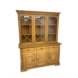 20th century pine glazed bookcase on cupboard, projecting cornice over three astragal glazed doors, the base fitted with three drawers and three panelled cupboards, on bracket feet