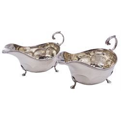 Pair of 1920's silver sauce boats, each of part faceted form with flying acanthus capped scroll handle, upon three hoof feet, hallmarked Adie Brothers Ltd, Birmingham 1922 and 1923, approximate total weight 7.59 ozt (236.2 grams)