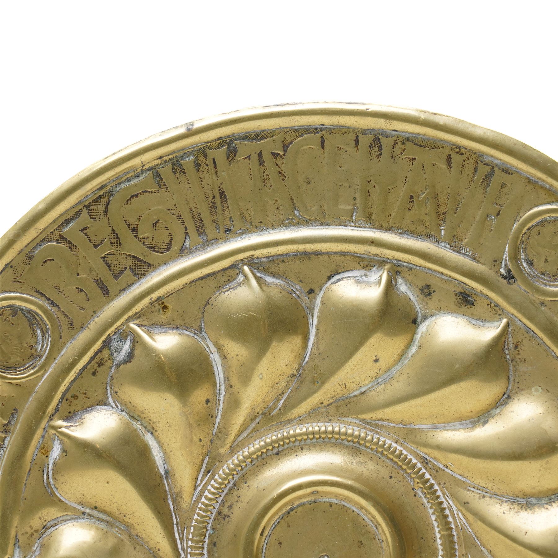 Central section of a 17th century Nuremberg brass alms dish, central rosette surrounded by Gothic inscription, intersected by roundels with engraved heads, D23cm 