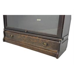 Globe Wernicke - early 20th century oak three-tier stacking library bookcase, three glazed sections enclosed by hinged and sliding doors, raised above a single lower drawer with metal drop handles