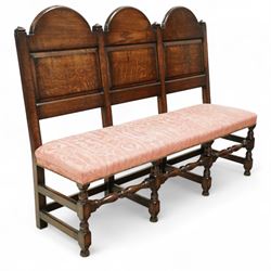 Bylaw of Ross On Wye - 17th-century design oak three-seat hall bench, triple arched panelled back, padded seat upholstered in pink damask fabric, raised on turned baluster legs united and turned front stretcher
